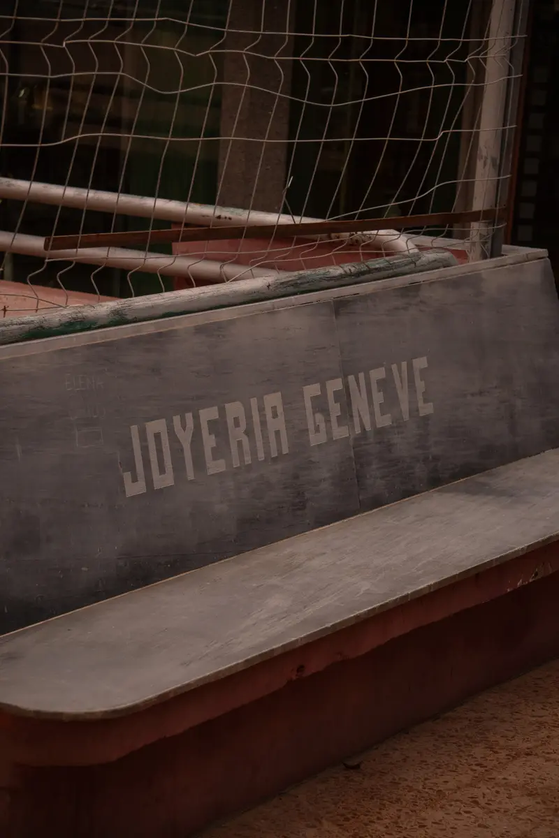 Una panchina di cemento con inciso il nome Joyería Geneve