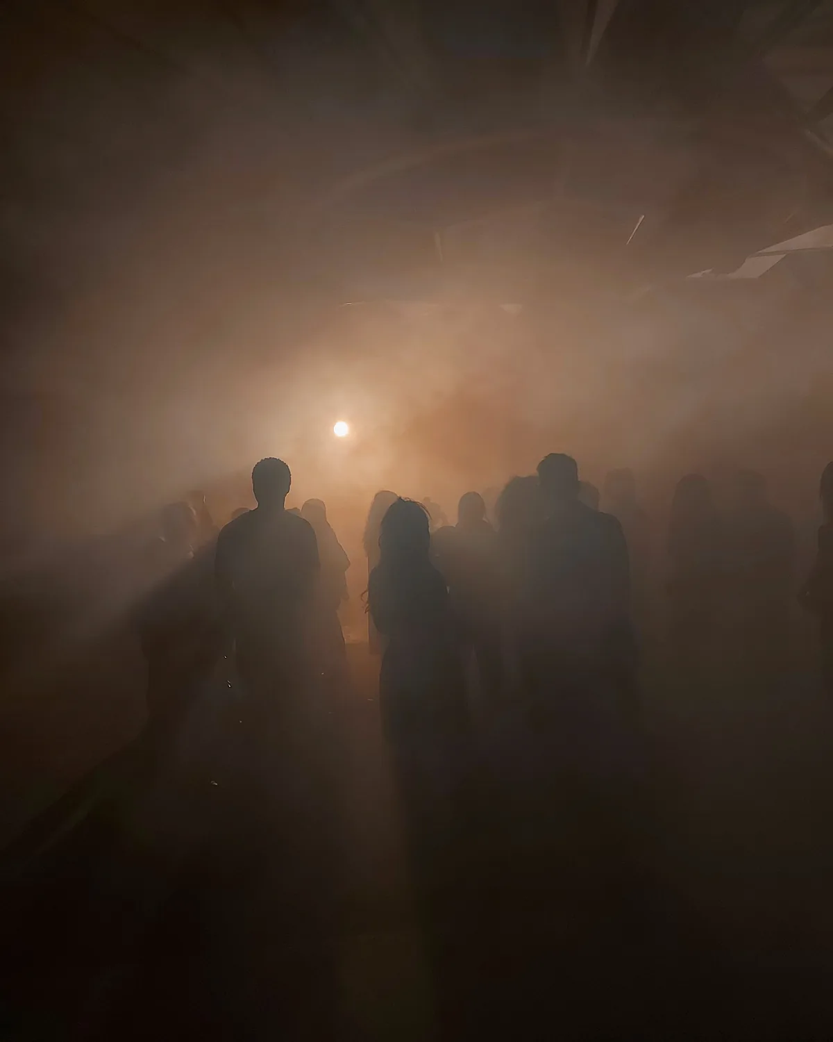 Sagome in controluce nella nebbia ambrata
