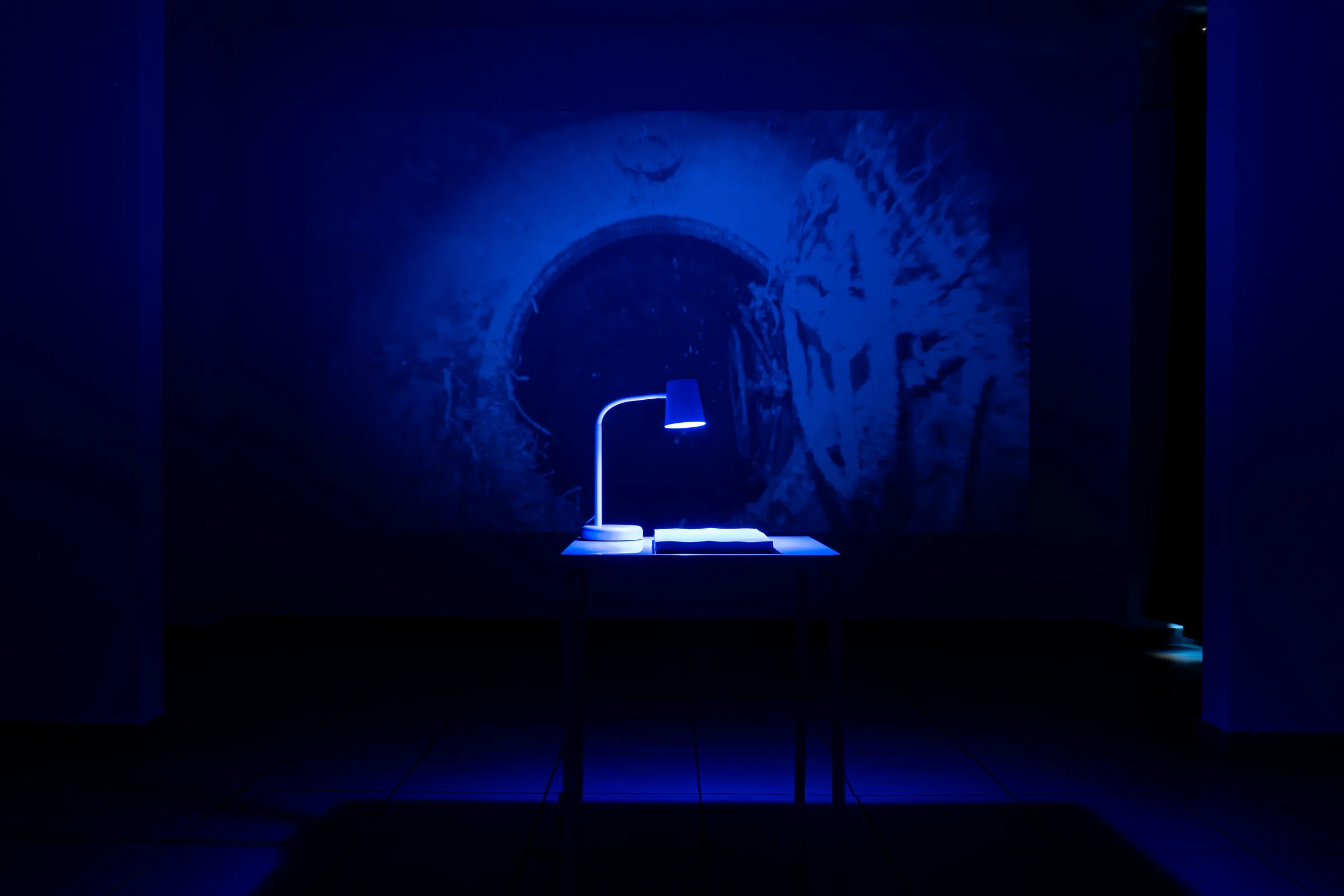 Sala in luce blu con una lampada su un tavolo